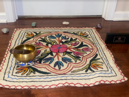 A mat, crystals, and singing bowl are incorporated into a meditative set up.