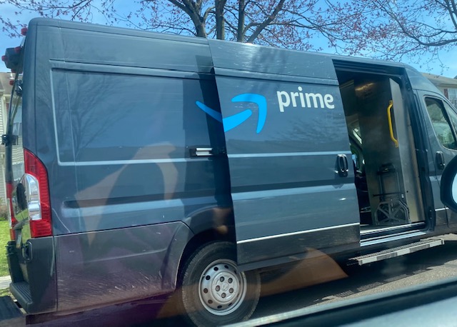Amazon prime truck stops in a neighborhood to make some deliveries.