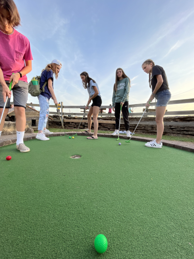 Teenagers playing mini golf at Freddy Hill