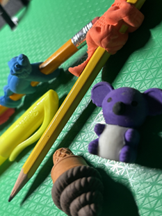 Animal and food erasers on and surrounding pencils and a highlighter.