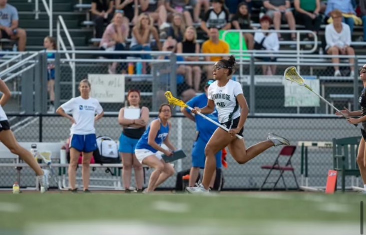 Makena Charles playing lacrosse on Pennridge High School home field 