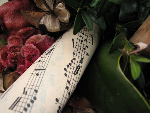 Sheet music surrounded by Christmas decorations.