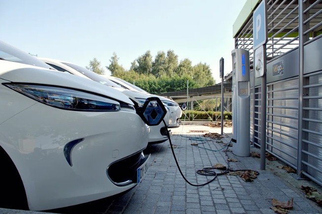 Image shows electric vehicles at a charging station.