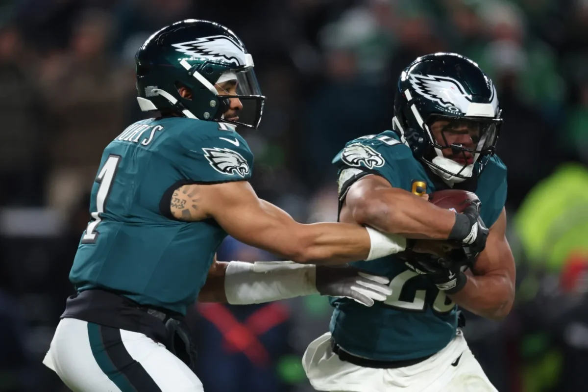 The Eagles' Jalen Hurts hands the ball to Saquon Barkley while competing against the San Francisco 49ers on January 11th, 2026, in Philadelphia, Pennsylvania.