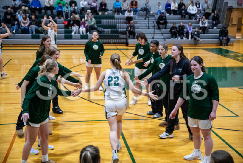 Samantha Murphy, jersey number 22, high-fiving teammates before a basketball game against Central Bucks South High School.