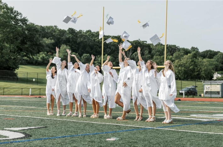 2025 graduating class throwing their caps in the air