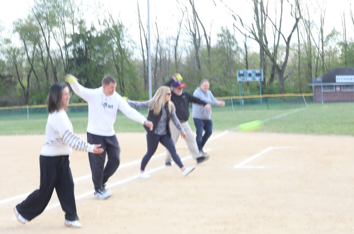 Action shot of selected teachers throwing the ceremonial first pitch.